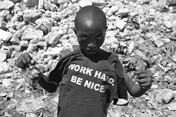 Haitian boy poses with a T-shirt<br>saying 'Work hard. Be nice'.<br>Photo: Serge McKenzie